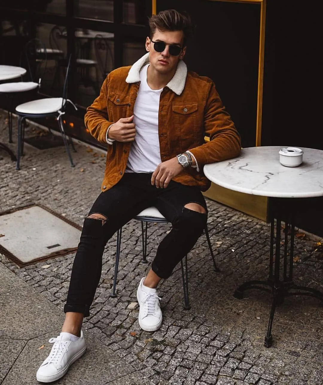 Stylish young man wearing a modern tailored suit with trendy accessories, showcasing the latest men's fashion trends for 2025